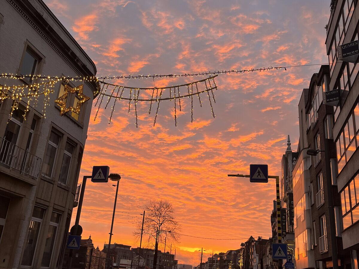 Straat in het centrum bij zonsopgang, met feestverlichting boven de weg